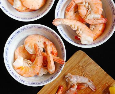 cooked shrimp dressed with lemon juice in china bowls